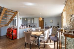 a kitchen and dining room with a wooden table and chairs at La Résidence Périgourdine Meublé Tourisme 5 étoiles Luxe in Anlhiac