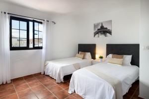 two beds in a room with white walls at Villa Europa in Nazaret +37 photos