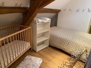 a small bedroom with a bed and a crib at Au Pied de Troncais in Coust