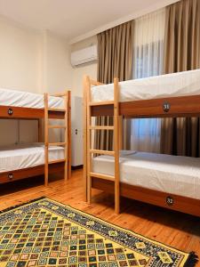 a room with two bunk beds and a rug at Balkan Hostel in Tirana