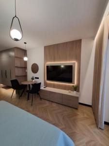 a living room with a large television and a table at Apartamenty Skalny Loft in Karpacz