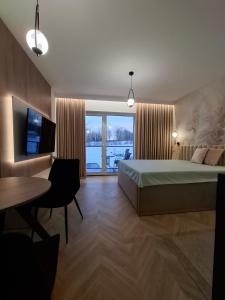 a bedroom with a bed and a desk and a television at Apartamenty Skalny Loft in Karpacz