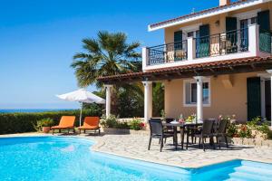 a villa with a table and chairs next to a swimming pool at Villa Zeus in Spartià