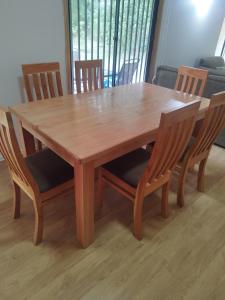 a wooden table and chairs with a wooden table and chairsktop at Pucón, casa en parcela in Pucón +4 photos