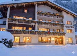 a hotel in the snow with christmas decorations at Pension Grein in Pfunds