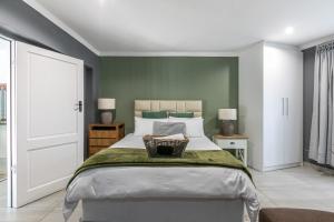 a bedroom with a large bed and green walls at Bella on St James in Johannesburg