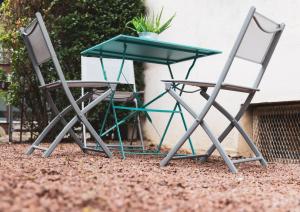 two chairs and a table and a table at L'Évolution, 1 suite et jardin privé in Vesoul