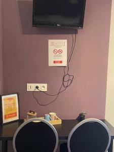 a room with two chairs and a tv on a wall at Le logis Katia in Saumur