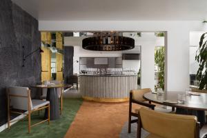 a restaurant with tables and chairs and a bar at Íz Hotel Conceito in Goiânia