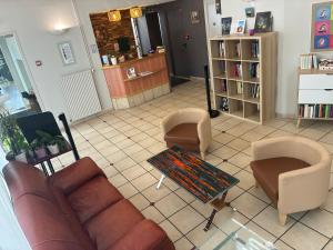 a living room with a couch and two chairs at Logis Hôtel du Commerce in Volvic