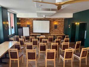 a conference room with a table and chairs and a screen at Logis Hôtel du Commerce in Volvic