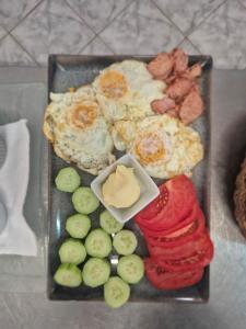 a plate of breakfast food with eggs and vegetables at Guest House Compass in Lozenets