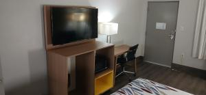 a living room with a flat screen tv on a entertainment center at Red Roof Inn Leeds in Leeds