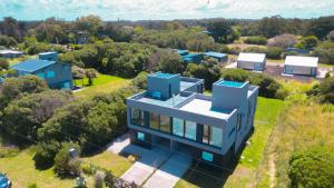 an aerial view of a blue house with trees at Marea Baja - Casa con vista al mar para 6 PAX con parrilla en Cruz del Sur, Chapadmalal - Hola Sur in Chapadmalal