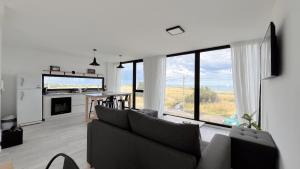 a living room with a couch and a large window at Marea Baja - Casa con vista al mar para 6 PAX con parrilla en Cruz del Sur, Chapadmalal - Hola Sur in Chapadmalal