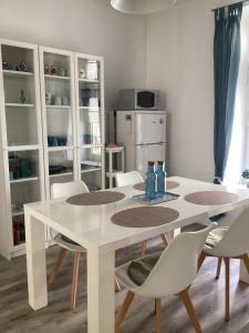 a white dining table and chairs in a kitchen at Les Apparts' Hotel du Canal in Châteaulin