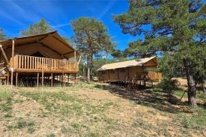 a large building with a porch and a roof at Camping Saint-Laurent-du-Verdon in Saint-Laurent-du-Verdon
