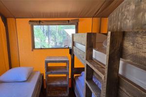 a small room with two bunk beds and a window at Camping Saint-Laurent-du-Verdon in Saint-Laurent-du-Verdon