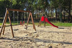 a playground with three swings in the sand at Camping Saint-Laurent-du-Verdon in Saint-Laurent-du-Verdon +14 photos