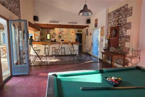 a living room with a pool table and a kitchen at Camping Saint-Laurent-du-Verdon in Saint-Laurent-du-Verdon
