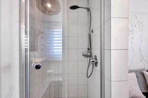 a shower with a glass door in a bathroom at Fewo SPECTRUM II in Uhldingen-Mühlhofen +19 photos