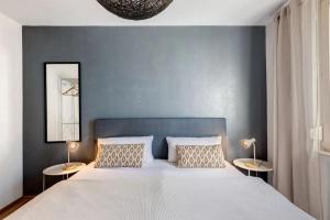 a bedroom with a bed with two tables and a mirror at Fewo SPECTRUM II in Uhldingen-Mühlhofen