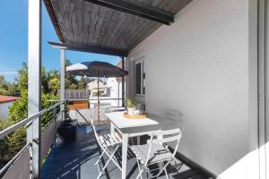 a balcony with a table and chairs and an umbrella at Fewo SPECTRUM II in Uhldingen-Mühlhofen