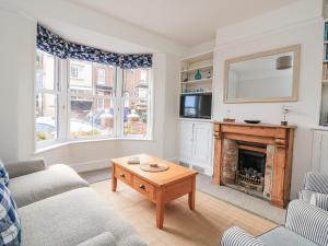 a living room with a couch and a fireplace at Shipwrights, 11 Coronation Road in Salcombe