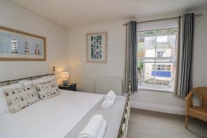 a bedroom with a large bed and a window at Shipwrights, 11 Coronation Road in Salcombe