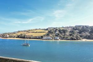 a boat in the water next to a beach at Shipwrights, 11 Coronation Road in Salcombe
