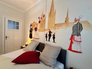 a bedroom with a bed with paintings on the wall at In De Wulf in Ieper +55 photos