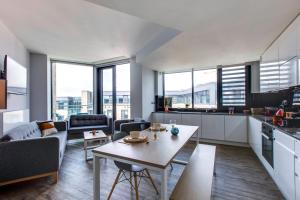 a living room with a table and a kitchen at Yugo Explore New Mill in Dublin