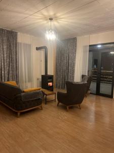 a living room with two chairs and a fireplace at Apartment MILU in Mestia