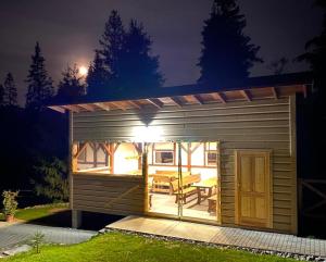 a small shed with a table and a patio at night at Chata Ballek Oravice in Vitanová