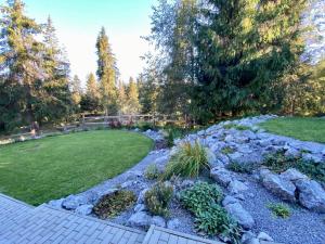a garden with rocks and a yard with a lawn at Chata Ballek Oravice in Vitanová