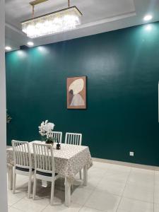 a dining room with a table and a green wall at Nafisa Homestay in Kepala Batas +15 photos