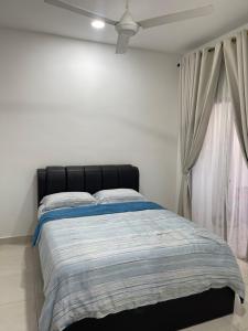 a bedroom with a bed with a black headboard and a window at Nafisa Homestay in Kepala Batas