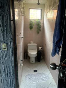 a small bathroom with a toilet and a window at Departamento Central Camionera in Guadalajara +9 photos