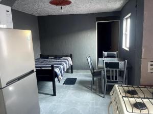 a room with two beds and a table and chairs at Departamento Central Camionera in Guadalajara