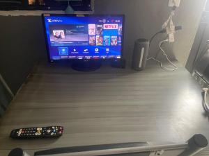 a computer monitor and two remote controls sitting on a desk at Departamento Central Camionera in Guadalajara