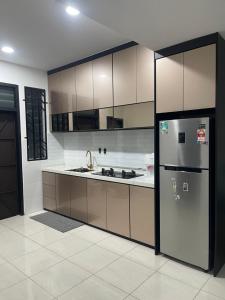 a kitchen with a sink and a refrigerator at Nafisa Homestay in Kepala Batas