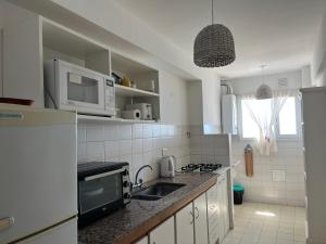 a kitchen with a sink and a microwave at Ballenas desde el balcon in Puerto Madryn