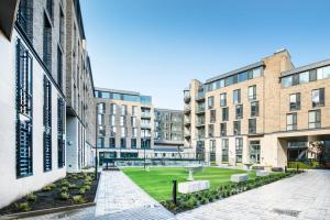 a courtyard with buildings and a park with a fountain at Yugo Explore New Mill in Dublin