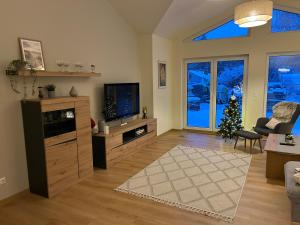 a living room with a television and a christmas tree at Ferienhaus Senzig Waldesruh in Königs Wusterhausen