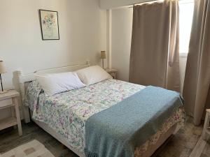 a bedroom with a bed with a blanket and a window at Ballenas desde el balcon in Puerto Madryn
