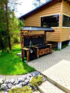 a house with a grill in front of it at Chata Ballek Oravice in Vitanová +30 photos