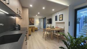 a kitchen and living room with a table and chairs at Myronos suite with jacuzzi in Piraeus