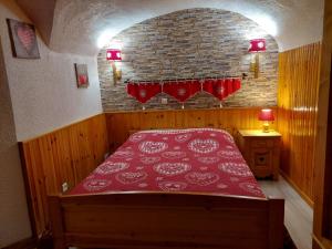 ein Schlafzimmer mit einem roten Bett in einer Backsteinwand in der Unterkunft Gîte Val Cenis Bramans E I in Bramans