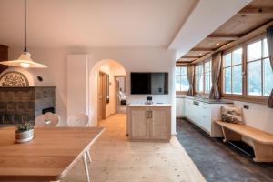 a large kitchen with a wooden table and a couch at Resciesa Hof in Ortisei