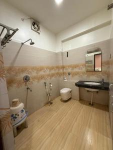 a bathroom with a toilet and a sink at Hotel Valentines in Prayagraj